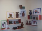 Salantų miesto bibliotekoje eksponuojama Dienos veiklos centro Salantų padalinio klientų keramikos  bei Vytauto Raudonio siuvinėjimo kryželiu darbų paroda.
